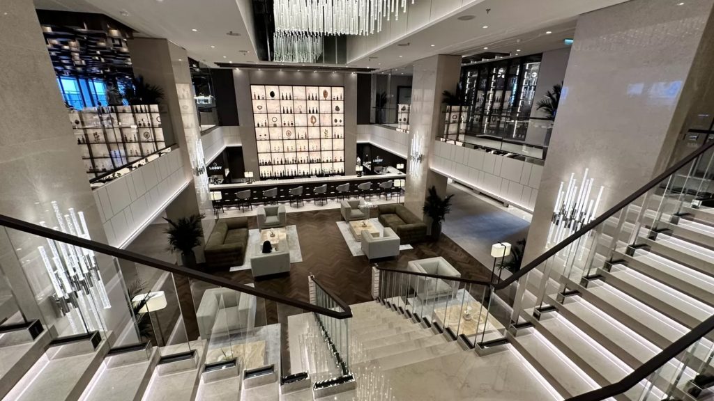 Luxurious hotel lobby featuring elegant seating areas, modern decor, and a stylish staircase, emphasizing unique travel experiences and boutique accommodations.